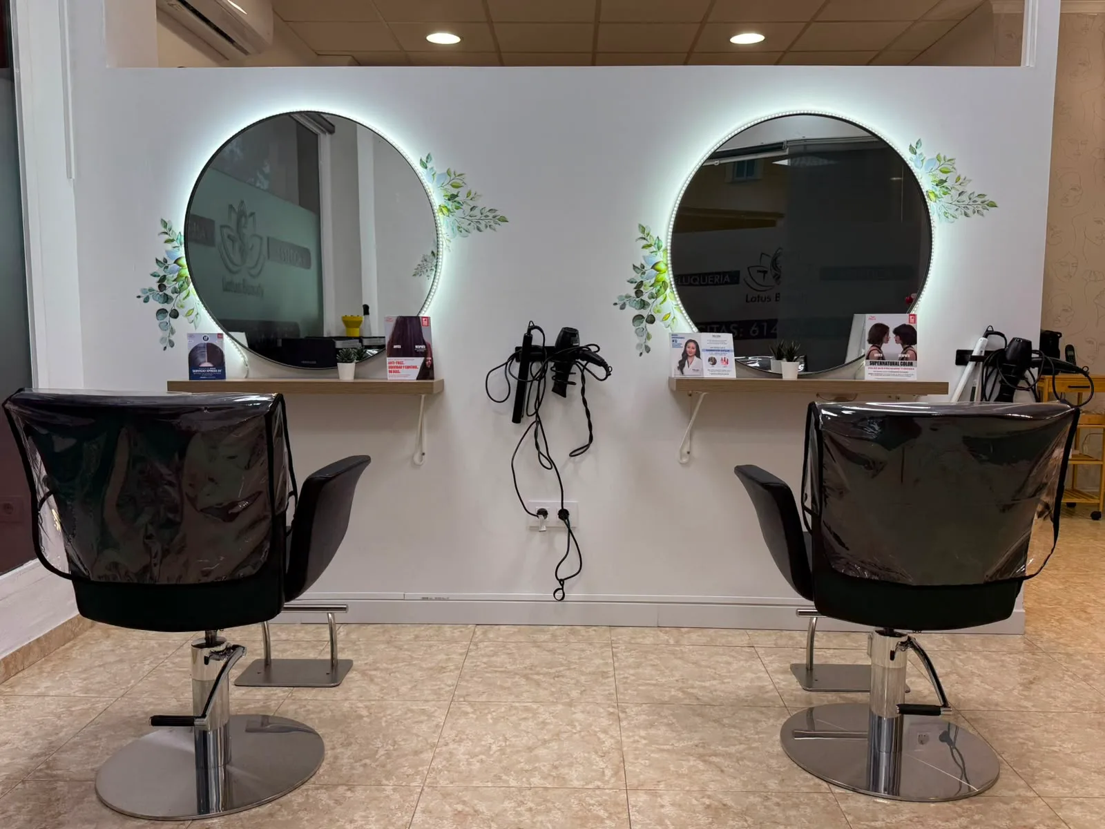 Zona de peluquería de Dayanna Beauty Studio en Puerto de Mazarrón: dos sillones frente a espejos redondos retroiluminados